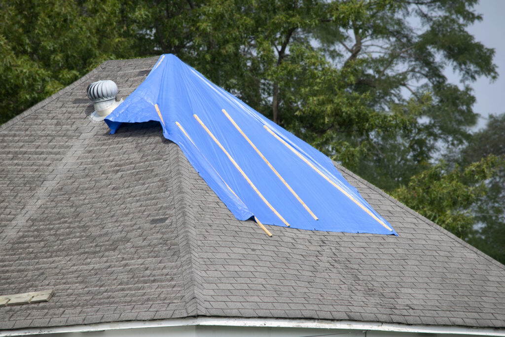 Picture shows a plastic roof covering patching a leaky roof.